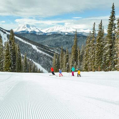Skiing down a slope with a family Kindred Resort Keystone